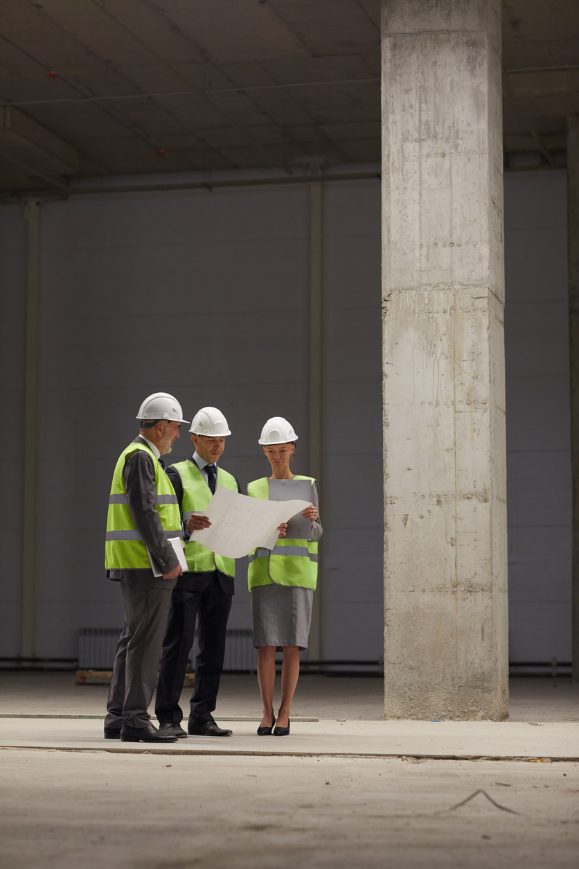 Inspection Committee Discussing Plans at Construction Site